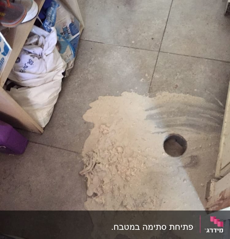 חול וכלי עבודה על רצפה עם חור